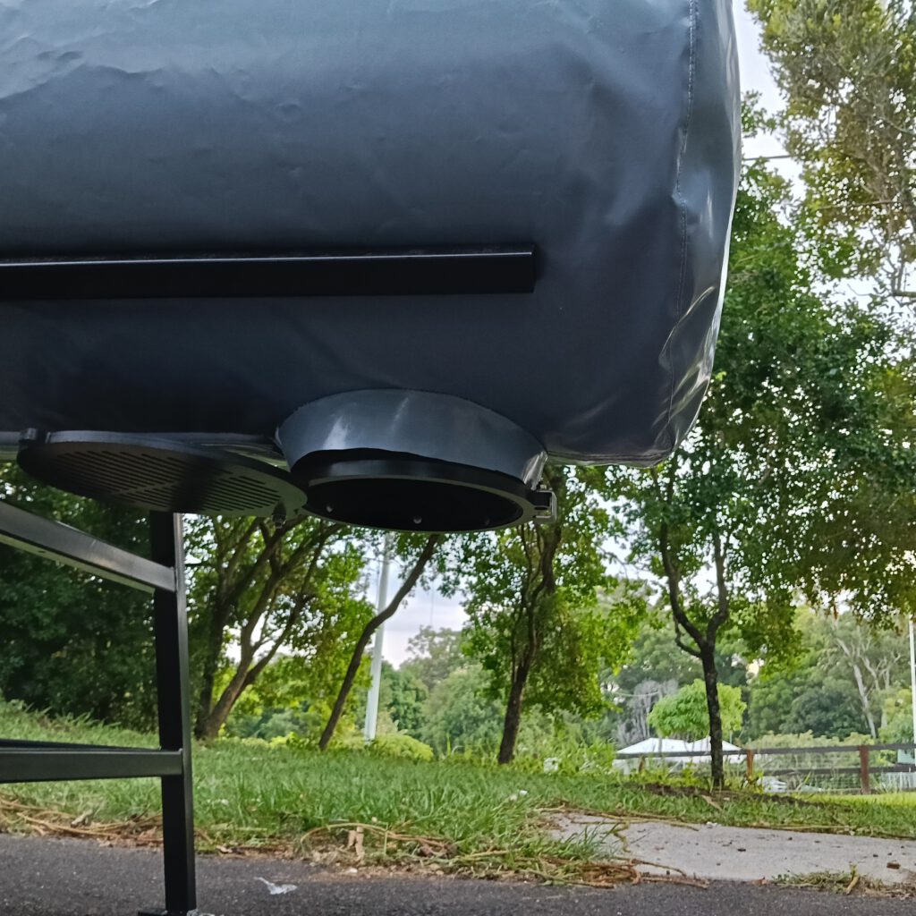 Close-up view of OSCA composter tank with round loading opening, mounted on black metal frame outdoors, showing the industrial composting equipment design for sustainable organic waste processing
