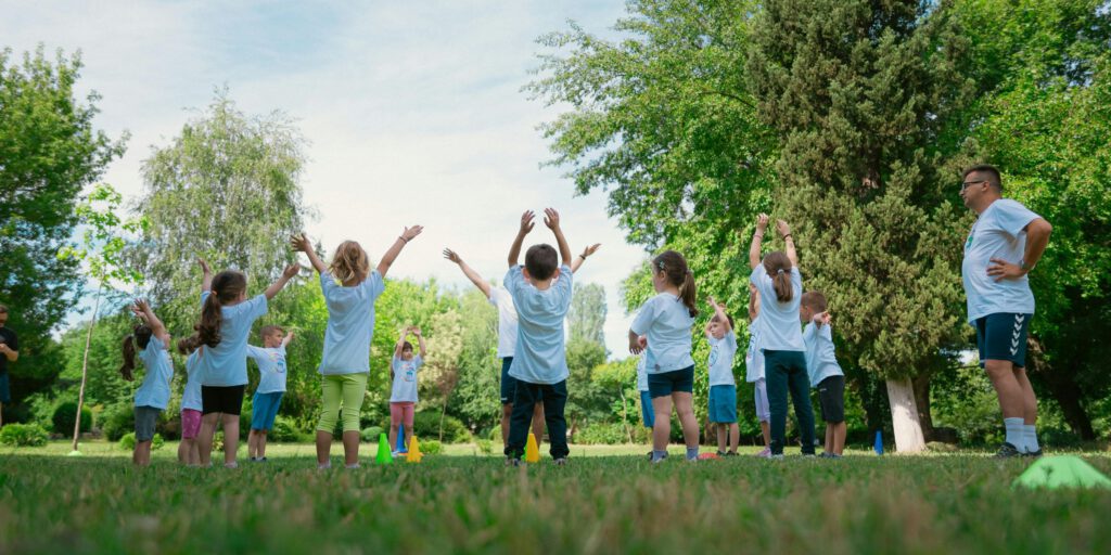 Group of children and OSCA facilitator in outdoor circle activity, demonstrating community engagement and environmental education about composting and sustainable organic waste management