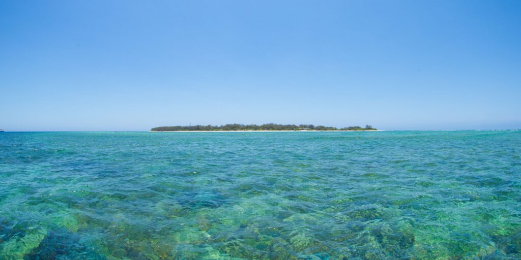 Lady Elliot Island surrounded by turquoise ocean water under clear blue sky, representing an eco-resort destination using OSCA composter for sustainable organic waste management and circular economy tourism operations